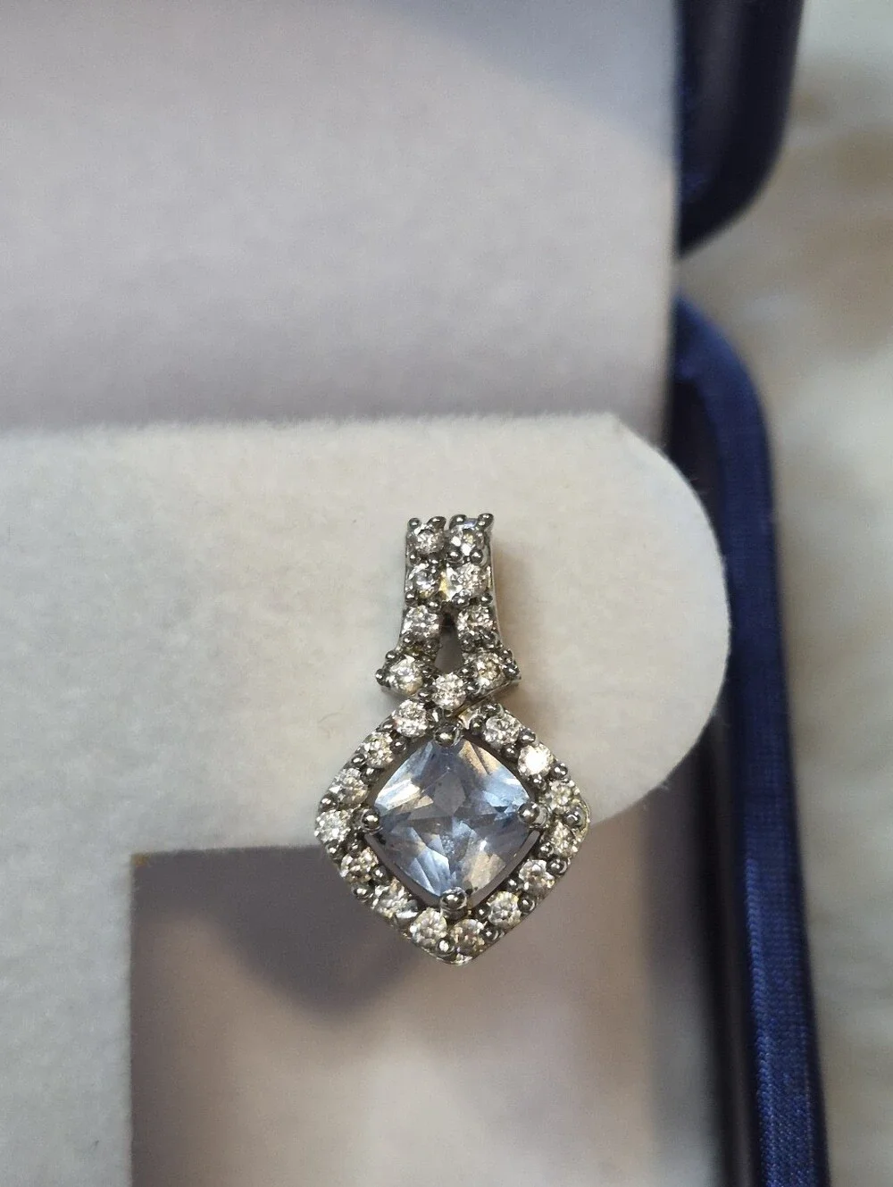 Brighton drop earrings feature a striking cushion-cut blue crystal center